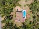 Aerial view of a house with a pool, surrounded by trees and a driveway at 2020 E Dolphin Dr, Englewood, FL 34223