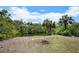 A backyard featuring lush greenery, a tranquil canal, and a charming brick firepit for outdoor gatherings at 2020 E Dolphin Dr, Englewood, FL 34223