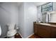Bathroom featuring a toilet, sink with cabinet, and a window that provides natural light at 2020 E Dolphin Dr, Englewood, FL 34223