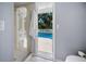 Bathroom with shower, toilet, and view of pool area at 2020 E Dolphin Dr, Englewood, FL 34223