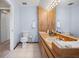 Well-lit bathroom with light blue walls, wood vanity, and decorative towels at 2020 E Dolphin Dr, Englewood, FL 34223