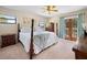 Bedroom featuring a four post bed, windows, blue curtains, and dark wood furniture at 2020 E Dolphin Dr, Englewood, FL 34223