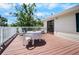 Spacious outdoor brown wood deck with table and chairs, surrounded by trees at 2020 E Dolphin Dr, Englewood, FL 34223