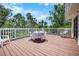 Brown wood deck with table and chairs, and a white railing at 2020 E Dolphin Dr, Englewood, FL 34223