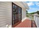 Outdoor deck with brown wood, white railing, and double doors at 2020 E Dolphin Dr, Englewood, FL 34223