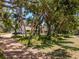 A classic home is nestled among trees, featuring a long driveway and well-manicured lawns at 2020 E Dolphin Dr, Englewood, FL 34223
