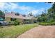 A well-maintained home with a manicured lawn, colorful flower beds, and a stone driveway at 2020 E Dolphin Dr, Englewood, FL 34223