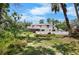 A bright, two-story house boasts dual balconies and a spacious fenced yard with a pristine white fence at 2020 E Dolphin Dr, Englewood, FL 34223