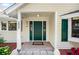 Attractive front entrance featuring a dark green door, classic sidelights, and stylish exterior lighting at 2020 E Dolphin Dr, Englewood, FL 34223