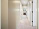 Well-lit hallway with neutral paint, leading to a room with an accent wall and a large window at 2020 E Dolphin Dr, Englewood, FL 34223