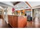 Kitchen island with granite countertops, wood cabinets, stainless steel fridge, and wood floors at 2020 E Dolphin Dr, Englewood, FL 34223