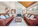Comfortable living room with brick fireplace, wood-paneled ceiling, and leather sofas for relaxed living at 2020 E Dolphin Dr, Englewood, FL 34223