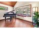 Cozy living room featuring a grand piano, bay window seat, and wood-paneled vaulted ceiling at 2020 E Dolphin Dr, Englewood, FL 34223