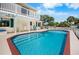 The backyard pool has a red brick trim and has access to the patio and upstairs balcony at 2020 E Dolphin Dr, Englewood, FL 34223