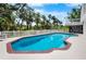 The backyard pool is surrounded by a fence line that is lined with lush vegetation at 2020 E Dolphin Dr, Englewood, FL 34223