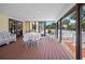 The screened porch features a dining table with wicker chairs overlooking the pool at 2020 E Dolphin Dr, Englewood, FL 34223