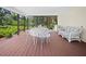 Large, screened sunroom with a dining set and wicker seating, with a wooded view at 2020 E Dolphin Dr, Englewood, FL 34223