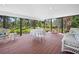 Large sunroom with an outdoor view, furnished with outdoor dining set and wicker seating at 2020 E Dolphin Dr, Englewood, FL 34223