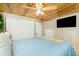 Cozy bedroom featuring wood paneling, ceiling fan, and a comfortable queen size bed at 221 Nippino E Trl, Nokomis, FL 34275