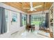 Cozy dining room features unique wood paneling, modern ceiling fan, and picturesque backyard views from multiple windows at 221 Nippino E Trl, Nokomis, FL 34275