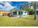 Charming light blue house with a matching awning, complimented by lush greenery and a well-maintained yard at 221 Nippino E Trl, Nokomis, FL 34275