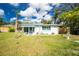 Exterior view of home with a well-manicured lawn and a small palm tree in the front yard at 221 Nippino E Trl, Nokomis, FL 34275