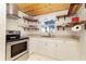 Bright kitchen with stainless steel appliances, white cabinets, and open shelving offering storage at 221 Nippino E Trl, Nokomis, FL 34275