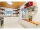 Galley kitchen with modern stainless steel appliances, white cabinetry, and open shelving at 221 Nippino E Trl, Nokomis, FL 34275