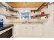 Bright kitchen with stainless steel appliances, white cabinets, and open shelving providing ample storage at 221 Nippino E Trl, Nokomis, FL 34275