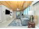 Cozy living room with wood paneling, plush seating, a modern ceiling fan, and elegant tile flooring at 221 Nippino E Trl, Nokomis, FL 34275