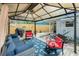 Spacious outdoor seating area under a covered patio featuring comfortable furniture and a grill at 221 Nippino E Trl, Nokomis, FL 34275