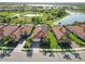 Scenic aerial view of a community featuring well-manicured lawns, lakes, and charming tile-roofed homes at 24181 Gallberry Dr, Venice, FL 34293