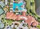 Overhead view of a community pool, clubhouse and tennis courts amidst lush landscaping and palm trees at 24181 Gallberry Dr, Venice, FL 34293