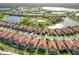Expansive aerial shot of a neighborhood featuring tiled roofs, lush lawns, and tranquil lakes winding throughout at 24181 Gallberry Dr, Venice, FL 34293