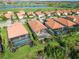 Aerial view showcasing a community with tile-roofed homes, screened-in pools, and a scenic golf course at 24181 Gallberry Dr, Venice, FL 34293