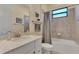 Well-lit bathroom featuring a shower-tub combo, white vanity, and elegant fixtures at 24181 Gallberry Dr, Venice, FL 34293