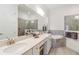 Bathroom featuring double sinks, white cabinets, soaking tub, and a glass shower at 24181 Gallberry Dr, Venice, FL 34293