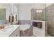 Bright bathroom featuring double sinks, soaking tub, and a glass shower with neutral finishes at 24181 Gallberry Dr, Venice, FL 34293