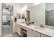 Bathroom with double sinks, white cabinetry, quartz countertops, and neutral finishes at 24181 Gallberry Dr, Venice, FL 34293