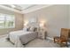 Bedroom featuring neutral tones, tray ceiling, carpet flooring, and ample natural light at 24181 Gallberry Dr, Venice, FL 34293