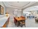 Elegant dining area with views into the bright kitchen, featuring a stylish light fixture at 24181 Gallberry Dr, Venice, FL 34293