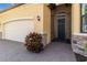 Close-up of the home's entrance, featuring a secure screen door and brick paver walkway at 24181 Gallberry Dr, Venice, FL 34293
