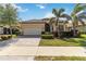 Home exterior showcasing a two-car garage, terracotta roof, and well-maintained landscaping at 24181 Gallberry Dr, Venice, FL 34293
