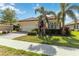 Residential exterior featuring mature palm trees and manicured landscaping that enhances curb appeal at 24181 Gallberry Dr, Venice, FL 34293