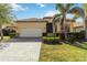 Home exterior showing a two-car garage, landscaped front yard, and a paver driveway at 24181 Gallberry Dr, Venice, FL 34293