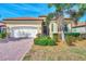 Charming single-story home with red tile roof, paver driveway, and meticulously manicured landscaping at 24181 Gallberry Dr, Venice, FL 34293