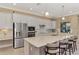 An expansive island with seating anchors this kitchen, featuring stainless appliances and white cabinetry at 24181 Gallberry Dr, Venice, FL 34293