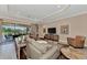 Bright living room featuring a large sectional sofa and sliding glass doors to the lanai at 24181 Gallberry Dr, Venice, FL 34293