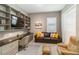 Office with built in shelving and cabinets, desk, and comfortable leather furniture at 24181 Gallberry Dr, Venice, FL 34293