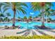 A tranquil swimming pool nestled between mature palm trees with blue skies above at 24181 Gallberry Dr, Venice, FL 34293